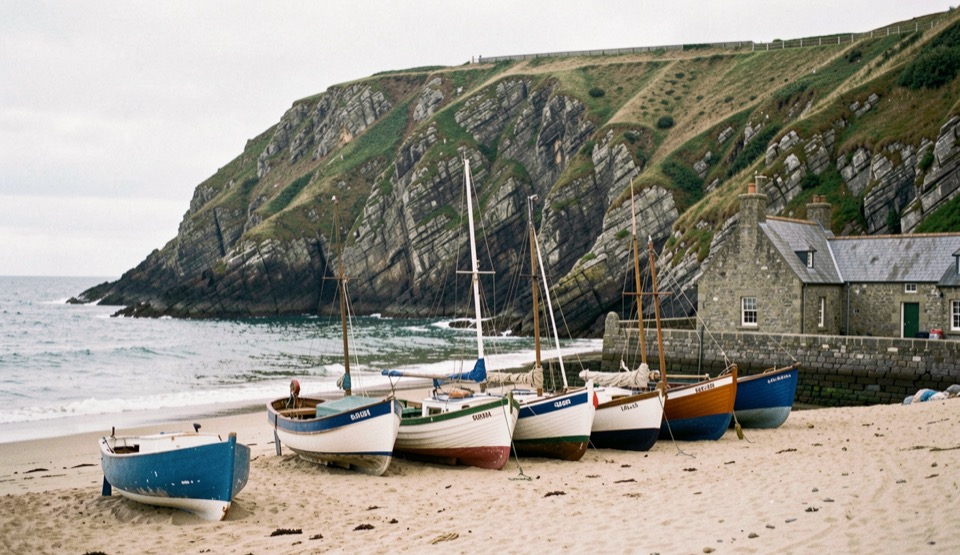 Une falaise du littoral breton domine un petit port de pêche abrité, coques échouées à marée basse sur le sable